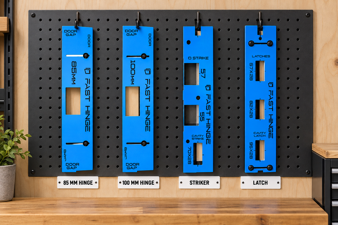Fast Hinge 85 mm, 100 mm, striker and latch jigs mounted and labelled on an organised workshop tool wall.