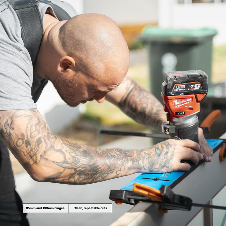 Person using a Milwaukee power tool on a glass surface